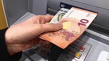 Eine Frau hebt in einer Bankfiliale in Höchenschwand (Landkreis Waldshut) Geld ab. (Aufnahme vom 28.10.2022) Bild: Juliane Schlichter
