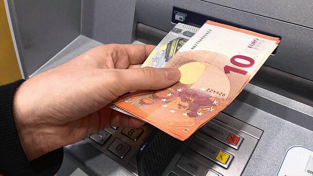 Eine Frau hebt in einer Bankfiliale in Höchenschwand (Landkreis Waldshut) Geld ab. (Aufnahme vom 28.10.2022) Bild: Juliane Schlichter