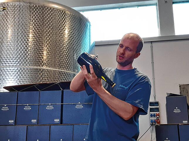 Maximilian Wagner zeigt, wie die Hefe von Hand aus der Flasche entfernt wird.