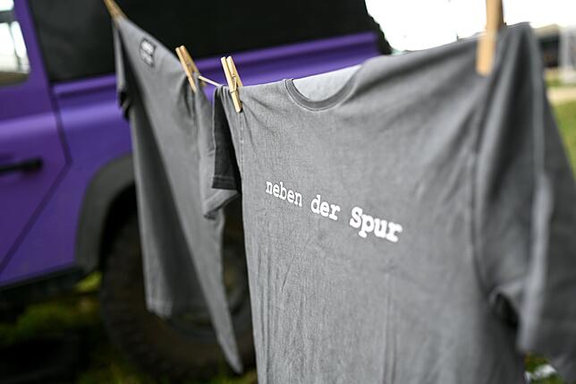 Survival- und Outdoor-Messe Ein T-Shirt mit der Aufschrift "neben der Spur" hängt bei der Survival- und Outdoor-Messe am Stand der Weltenbummler "Pistenkuh".