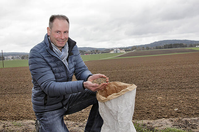 Landwirt Markus Hirt hat noch einen kleinen Rest Saatgut vom letzten Jahr übrig. Seine Blühwiese könnte im Mai auf der Fläche hinten ...