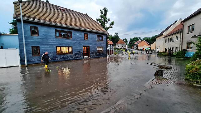 Die Feuerwehr ist in Wümbach in Thüringen im Einsatz, nachdem die Ortsdurchfahrt nach Starkregen überschwemmt ist und gesperrt werden ...