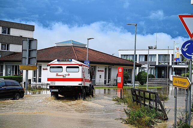 Am Kreisverkehr in der Ortsmitte kämpft sich am Vormittag des 26. Juni 2024 ein Unimog der Johanniter durch die Fluten. Innerhalb einer ...