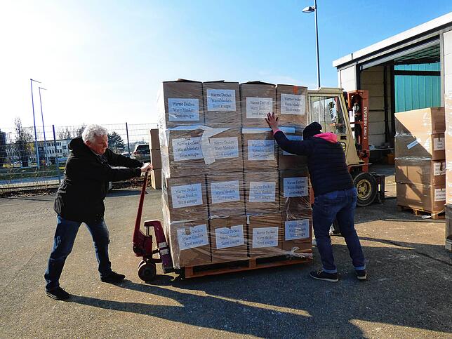 Am Dienstagmorgen verladen die Helfer die Paletten mit den dringend benötigten Hilfsgütern aus der Halle in die Transporter.