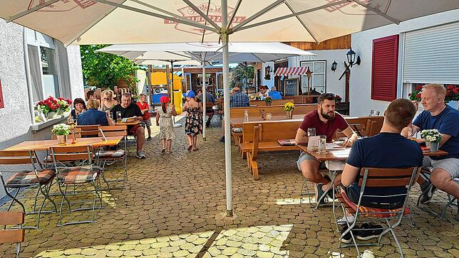 Im Biergarten sitzen Jung und Alt an den Tischen verteilt.