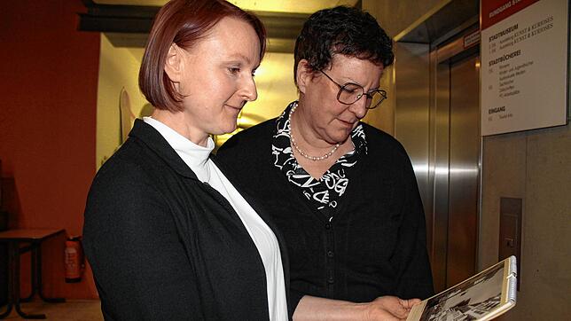 Sybille Trefflich (links) und Claudia Rinkenburger, Tochter von Gustav IV. Hotz, betrachten einen Kalender mit Bildern aus dem Archiv ...