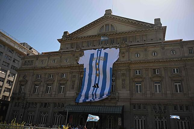 Ein großes argentinisches Trikot mit der Aufschrift „Champions of the world“ hängt an der Fassade des Colon Theaters in ...