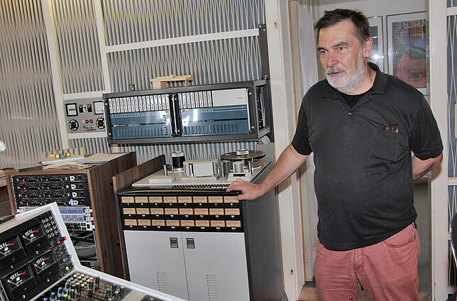Friedhelm Schulz steht neben einem 24-Spur Ampex-Tonbandgerät, welches derzeit wieder instand gesetzt wird.