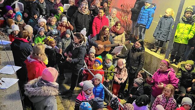Die Kinder des Waldkindergartens und des Dangstetter Kindergartens singen gemeinsam auf der Treppe beim Weihnachtsmarkt in Dangstetten. ...