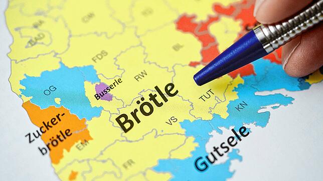 Ein Mann Thomas Liebscher zeigt in einem Mundart-Atlas auf die Wörter &bdquo;Zuckerbrötle&ldquo;, &bdquo;Brötle&ldquo;, ...