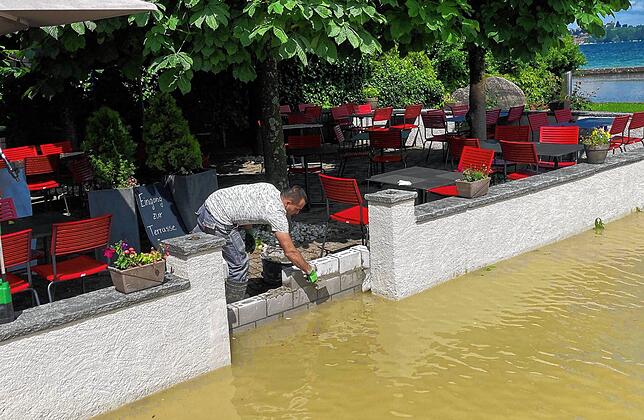 Biergarten mit Seeblick, nahe wie selten: In Berlingen wird lieber noch eine Lage Steine mehr auf die improvisierte Flutmauer gepackt.