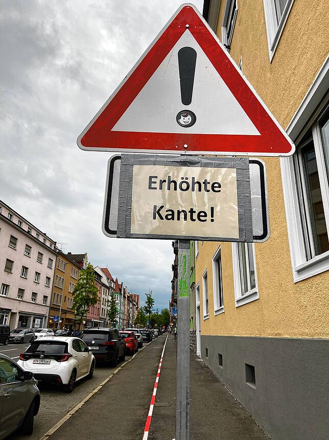 Ein mobiles Schild weist auf den Absatz zwischen Geh- und Radweg hin.