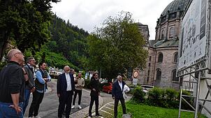 Kollegsdirektor Hans-Martin Rieder (Mitte) erläutert die Einzelheiten zum PVT-Anlagenprojekt, die auf dem Bauschild festgehalten sind. ...
