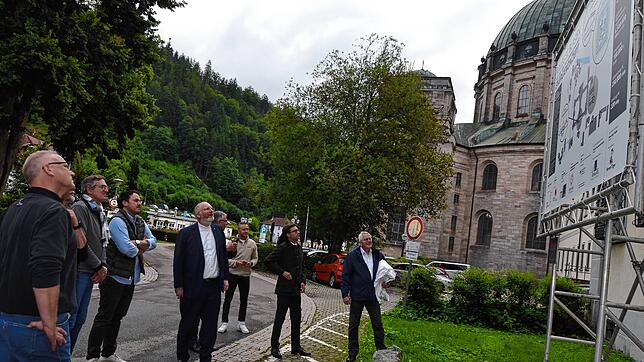 Kollegsdirektor Hans-Martin Rieder (Mitte) erläutert die Einzelheiten zum PVT-Anlagenprojekt, die auf dem Bauschild festgehalten sind. ...