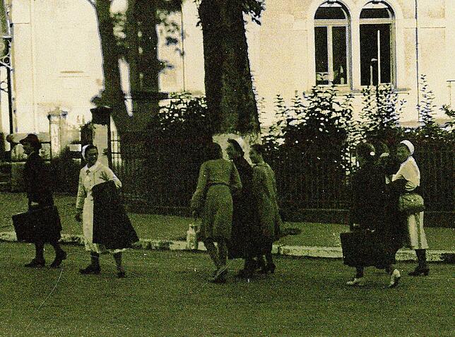 Krankenschwestern in Zivil und in Berufskleidung auf dem Weg zum Krankenhaus (1920er Jahre).