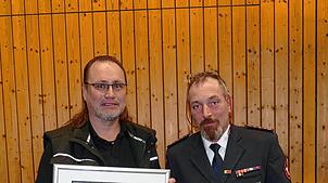 Aus den Händen von Kommandant Thomas Straub (rechts) nimmt Geschäftsführer Jörg Benkler die Auszeichnung des Landes Baden-Württemberg ...