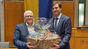 Einen prall gefüllten Geschenkkorb übergibt Landrat Zeno Danner dem Verwaltungsdezernenten Harald Nops zu dessen Abschied aus dem Amt. ...