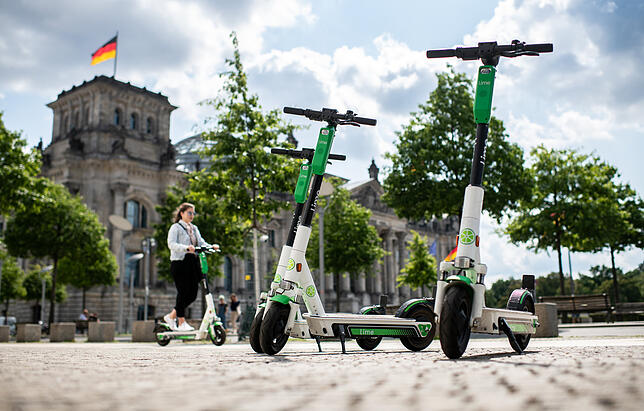 E-Scooter stehen vor dem Reichstagsgebäude, dem Sitz ves Deutschen Bundestags in Berlin.