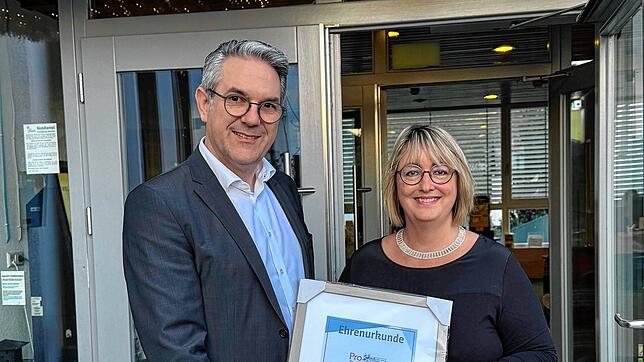 Volksbank-Vorstand Nicolas Mayer nimmt von Elisabeth Vogt die Urkunde für die 50-jährige Mitgliedschaft im Gewerbeverein Pro Bad ...