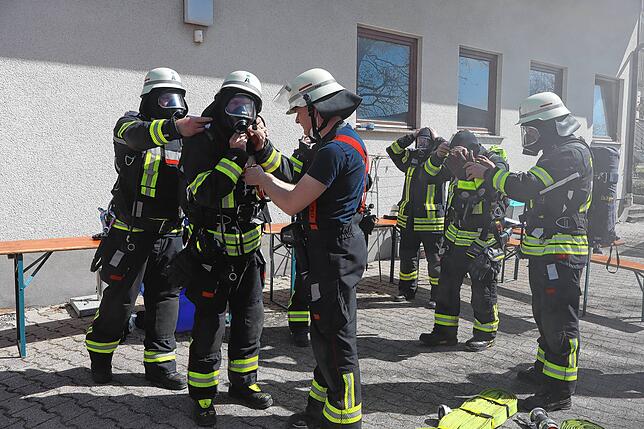 Bei der Feuerwehr wird der Teamgedanke großgeschrieben: Alle helfen sich gegenseitig, hier beim Anlegen der Atemschutzausrüstung.