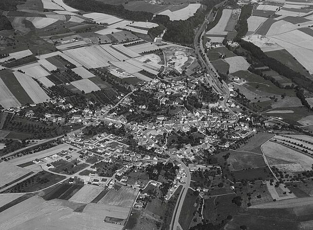 Auf diesem Foto von Nenzingen, das im August 1975 entstanden ist, gibt es einen leeren Platz an der Kurve zur Orsinger Straße. Daneben ...