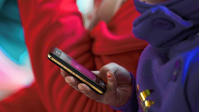 Eine Schülerin hält während einer Pause in der Mittelschule St. Nikola in Passau (Niederbayern) eine Telefon in der Hand, aufgenommen am ...