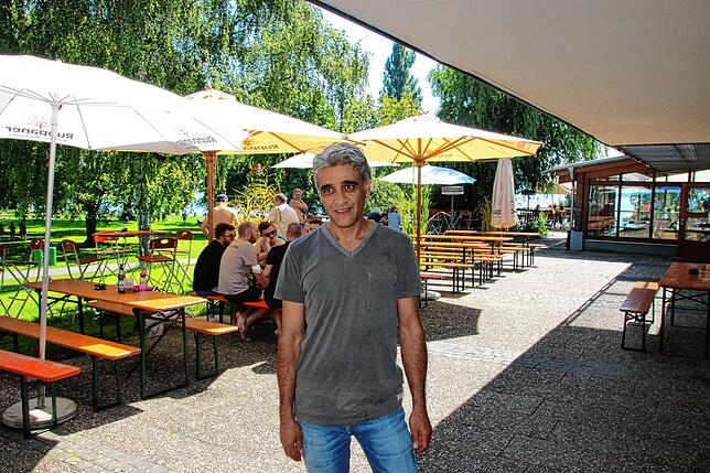 Ibrahim Yildirim vom Hörnle steht vor dem Bänken, die zum Kiosk gehören. Im Hintergrund geht es zu seinem Restaurant.
