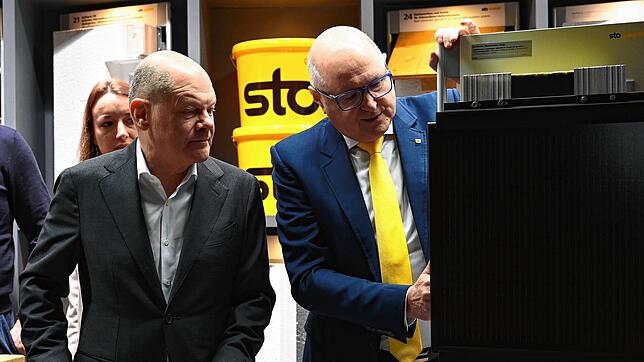 Diese Fassadenverkleidung erzeugt Strom: Michael Keller (rechts) führt Bundeskanzler Olaf Scholz bei Sto Innovation „made in Germany“ vor.