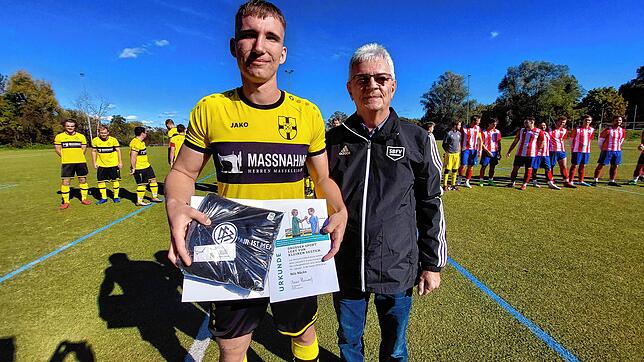 Nils Näcke hat die Fair-Play-Medaille des DFB vom Bezirksvorsitzenden Konrad Matheis erhalten. Dazu gab&lsquo;s noch ein Handtuch.