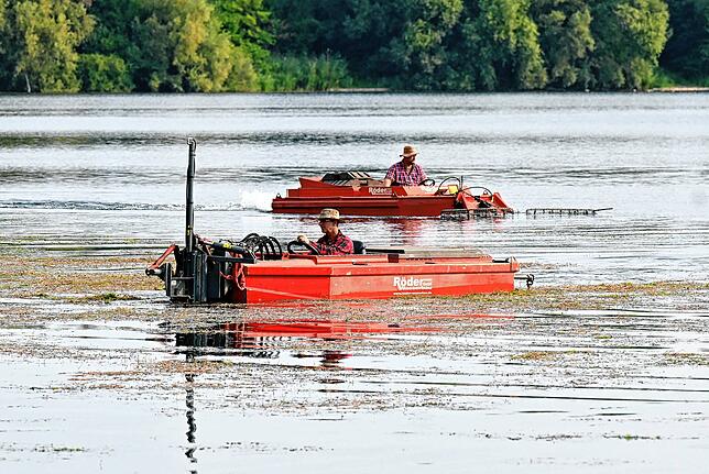 Mähboot (im Vordergrund) und Räumboot machen den Baggersee badetauglich.