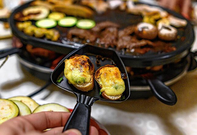 Nur echt mit Pfännchen: So kennt man Raclette in Deutschland.