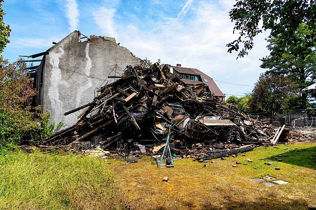 Am Montag türmen sich verkohlte Schuttreste neben dem Wohnhaus in der Bogengasse.