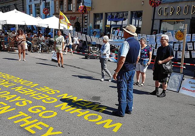 Peter Ganz (mit Hut) hält auf der Marktstätte eine Schweigeminute für Impfopfer ab.