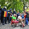 Eine Demonstrantin bläst in eine Vuvuzela vor einer Polizeikette.