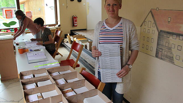 Stefanie Haberer zeigt in der Neudinger Festhalle einen der Wahlzettel, die auch der statistischen Erfassung des Wahlgeschehens dienen.