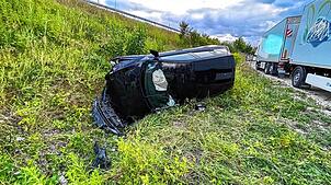Das Auto durchbricht am Mittwochabend, 16. Juli, die Leitplanke und bleibt am Hang auf der Seite liegen. Die Feuerwehr Konstanz befreit ...