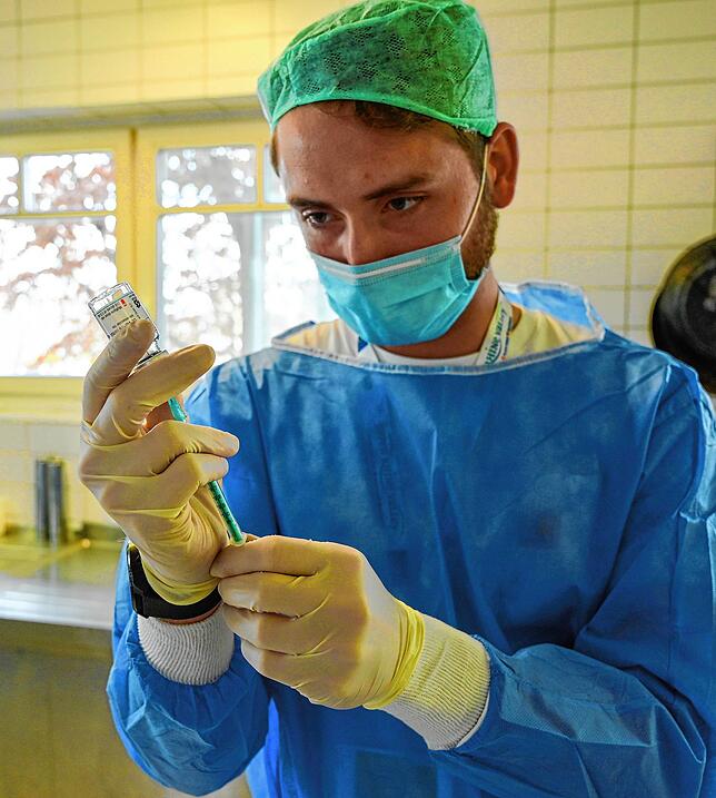 Medizinstudent Felix Remmersmann aus Freiburg zieht eine Spritze auf.