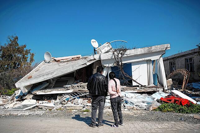 Erdbebenopfer überprüfen ihr zerstörtes Haus im Buyukdalyan-Distrikt von Hatay.