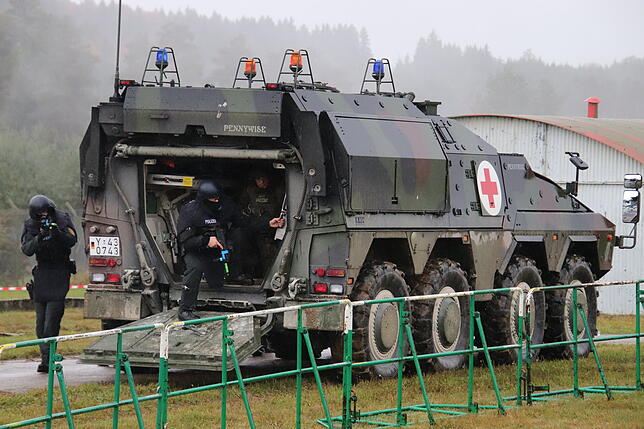Ein GTK-“Boxer“-Panzer der Bundeswehr rollt in die Szenerie. Er kann den Polizisten Schutz bieten – und dabei helfen, ...