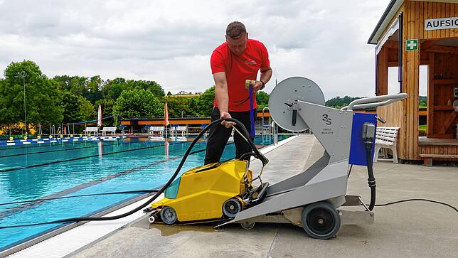 Hier zieht Axel Hirsch den Unterwasser-Reinigungsroboter aus dem Wasser.