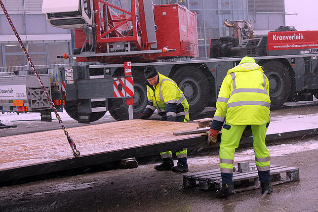 Ein Kran hievt die Planken an Ort und Stelle, wo die Mitarbeiter des Bauhofs, links Joachim Schelb, sie in den Boden einbauen. Bild: ...