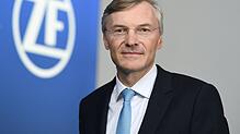 Wolf-Henning Scheider steht im ZF-Forum in Friedrichshafen neben einem ZF-Logo. Er zieht sich von der Konzernspitze zurück.