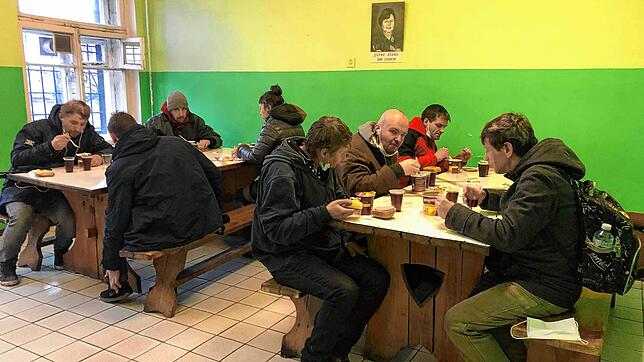 Obdachlose essen in der Suppenküche in St. Petersburg, die von Doris Epple eingerichtet wurde. An der Wand sieht man das Bild der ...