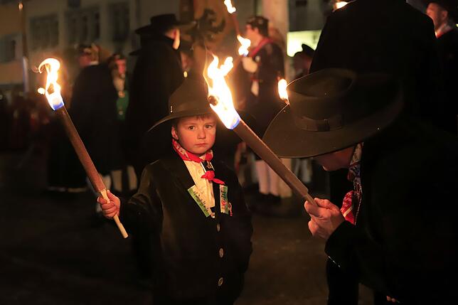Die Zimmermannsgilde begleitet den Nachtumzug und taucht mit ihren Fackeln Alte Wieber und Löwen in ein warmes Licht.