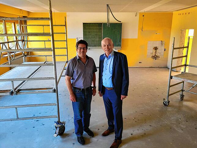 Architekt Jörn Thamm (links) und Bürgermeister Jürgen Maas führen durch die Baustelle in der Grundschule Horn.
