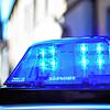 Ein Polizeiauto mit blinkendem Blaulicht steht vor einem Gebäude.