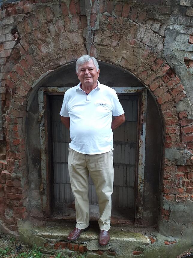 Werner Kramer vor dem Wehra-Kamin heute. Seit vielen Jahren sammelt er Bilder und Dokumente aus der Geschichte der Teppichfabrik.