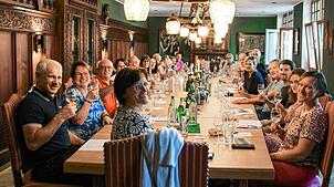 Die 20 Teilnehmer der Weinprobe des Stockacher Narrengerichts verkosten Wein, während sie Anekdoten des Stockacher Narrengerichts hören.