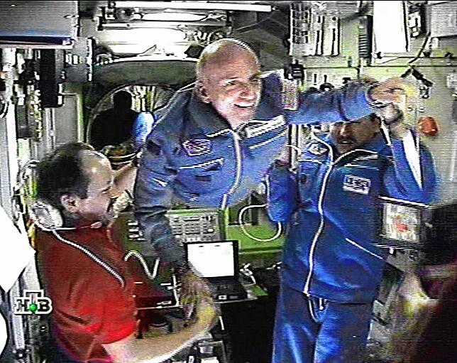 ISS Tito TV-grab taken from the Russian NTV channel shows Russian cosmonauts Talgat Musabayev (R) and Yuri Usachev (L) helping first-ever space ...