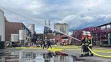 Zwei Feuerwehrleute der Werksfeuerwehr von Maggi löschen bei der Jahreshauptübung einen simulierten Brand in einer Halle. Für den ...
